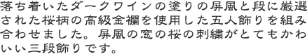 落ち着いたダークワインの塗りの屏風と段に厳選された桜柄の高級金襴を使用した五人飾りを組み合わせました。屏風の窓の桜の刺繍がとてもかわいい三段飾りです。